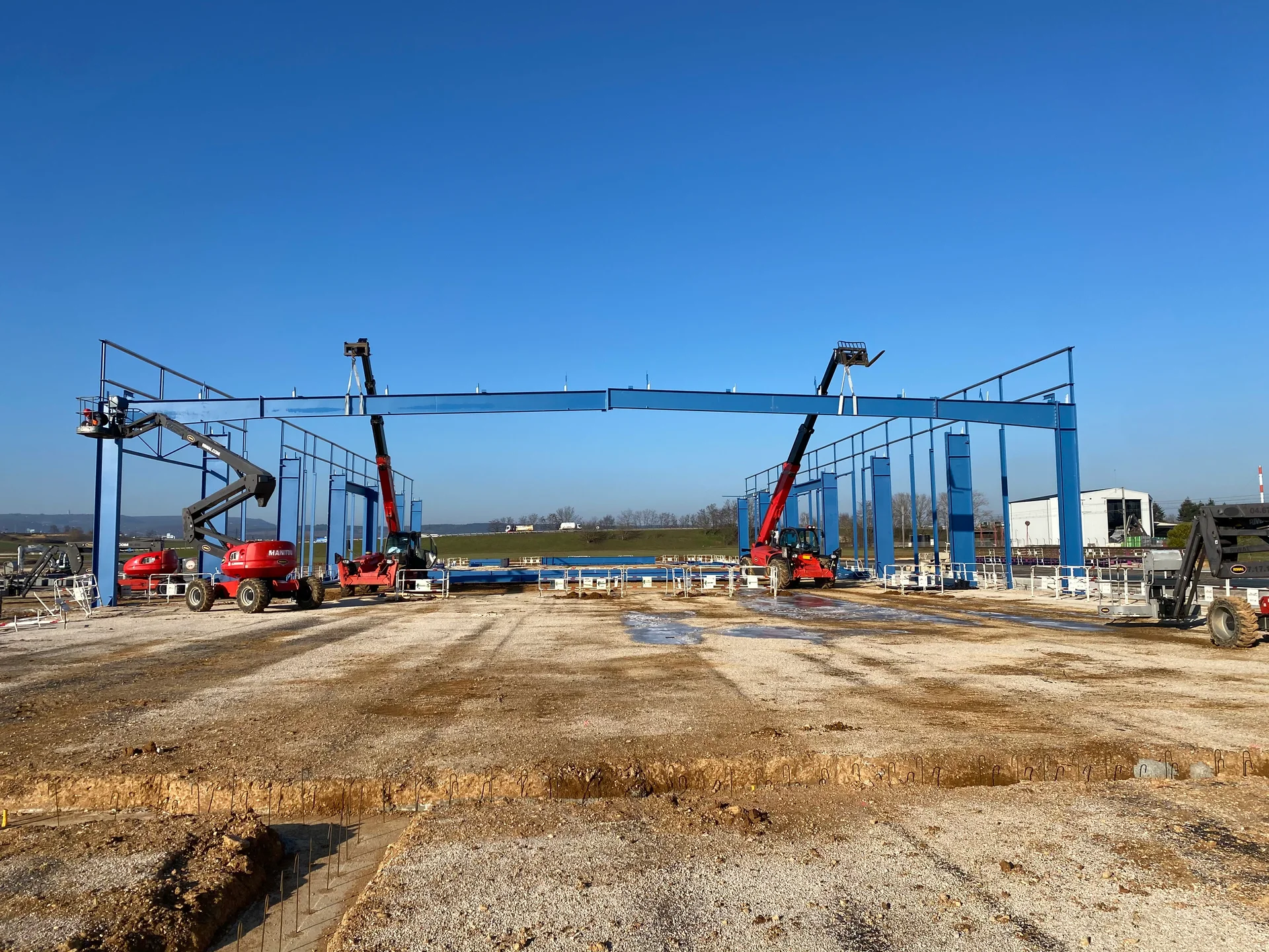 Levage de la charpente métallique industrielle avec deux grues